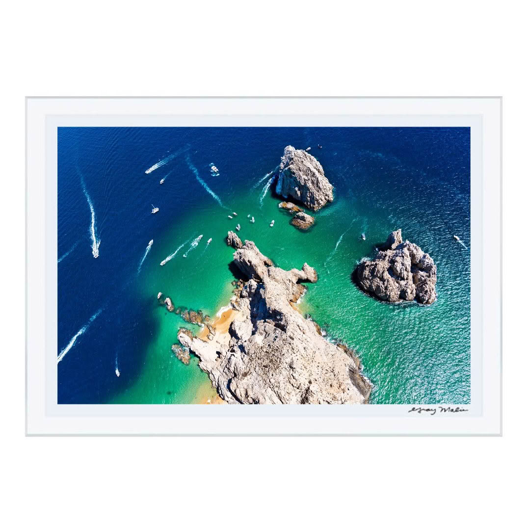 Aerial view of boats near rocky islets in clear blue sea