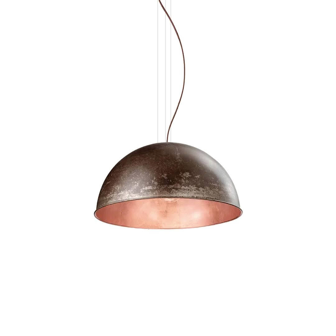 Aged copper pendant light hanging on a wire.