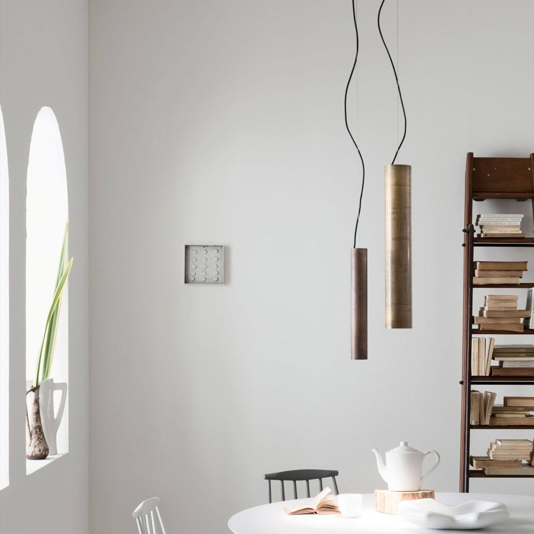 Minimalist dining room with hanging lights and white walls