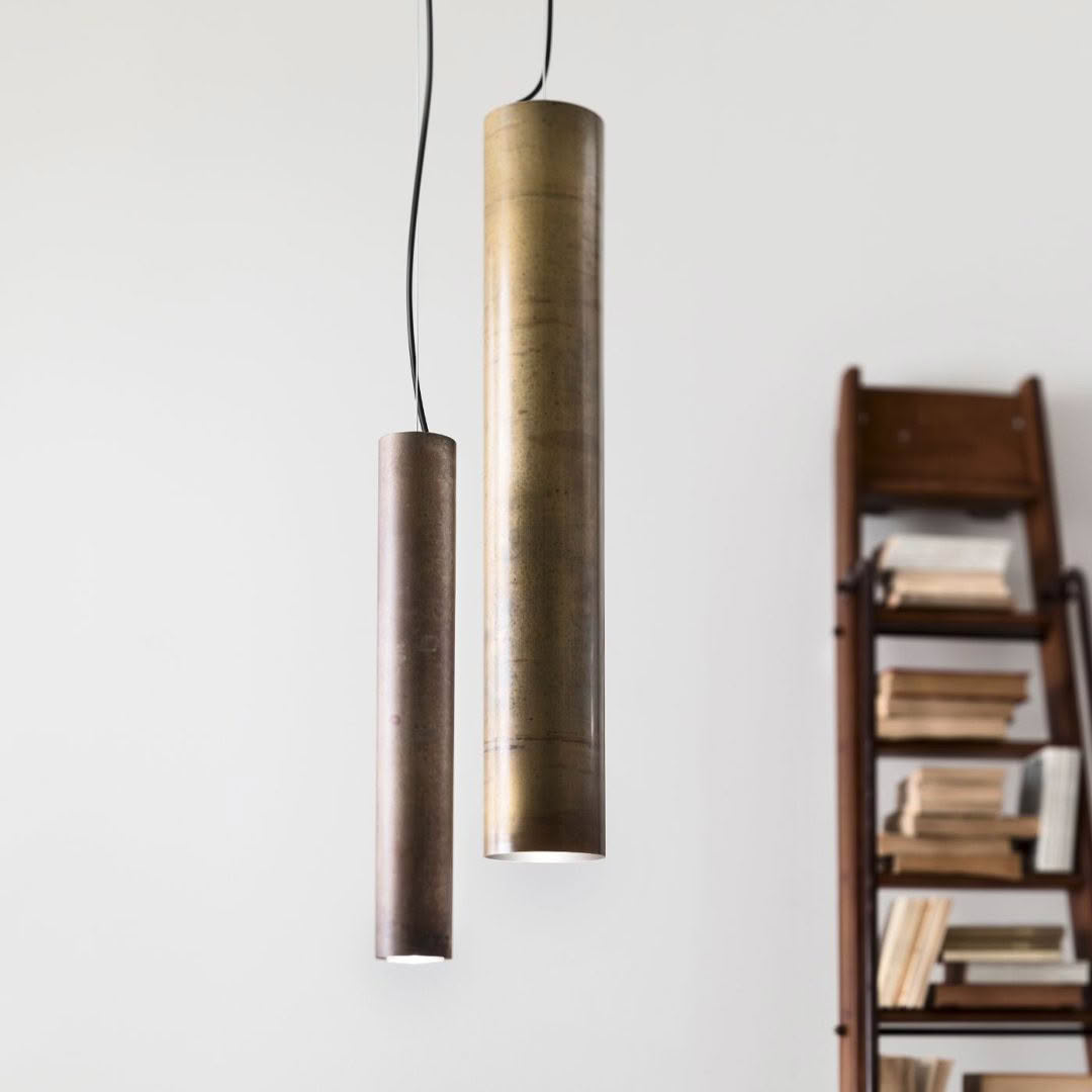 Minimalist pendant lights hanging beside wooden bookshelf