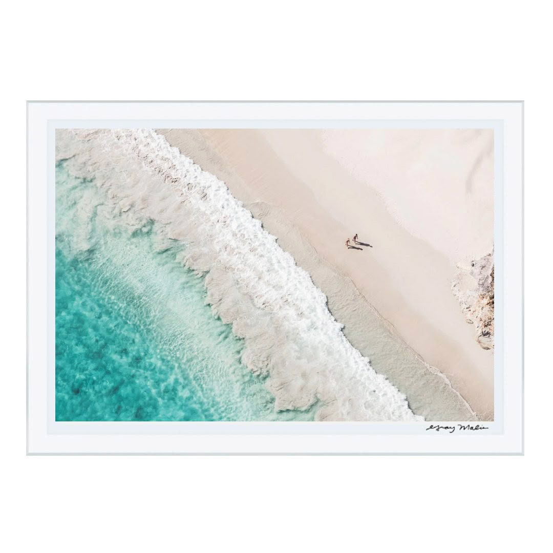 Aerial view of waves hitting sandy beach with person