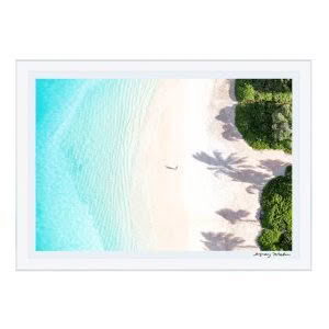 Aerial view of person on bright beach with shadows
