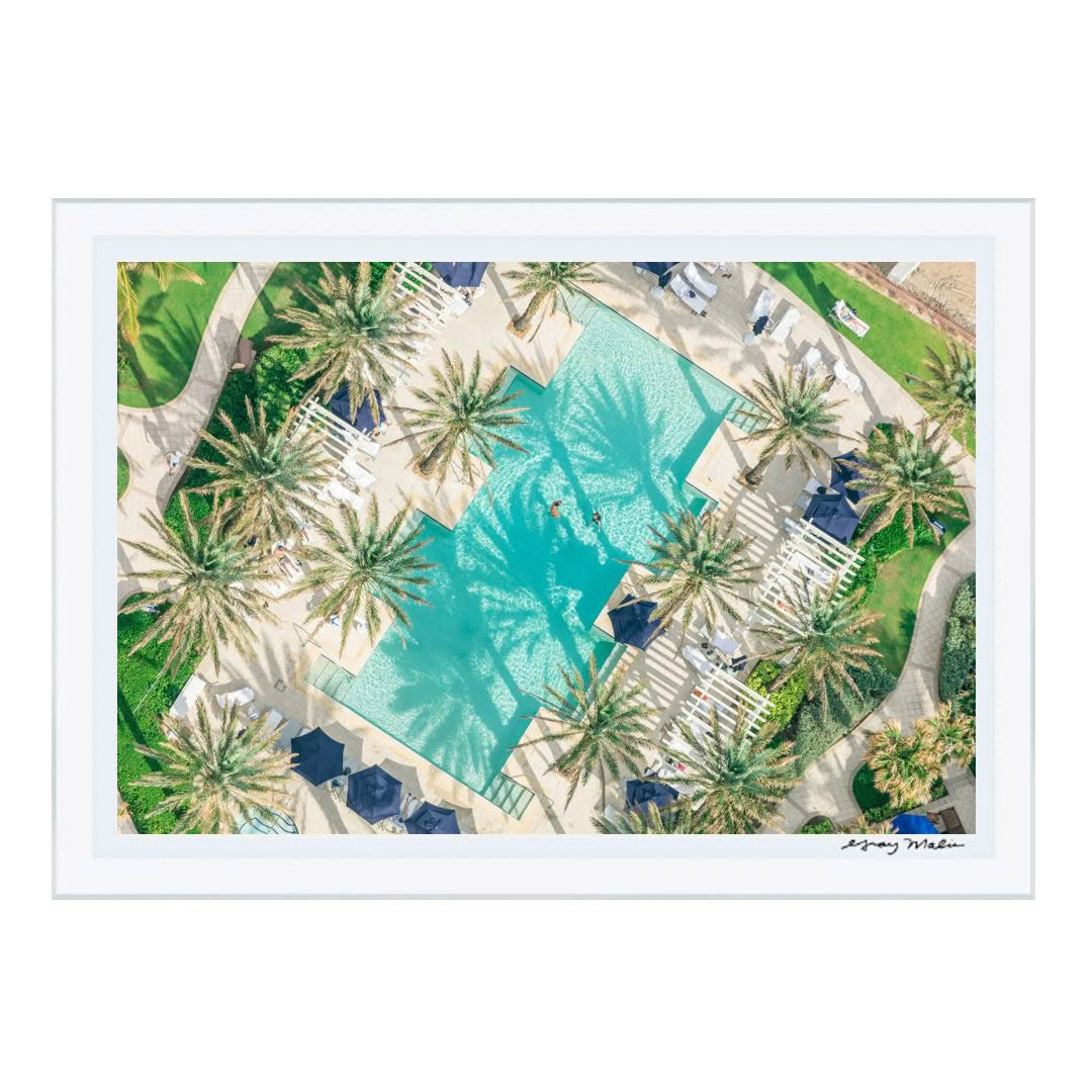 Aerial view of resort pool surrounded by palm trees