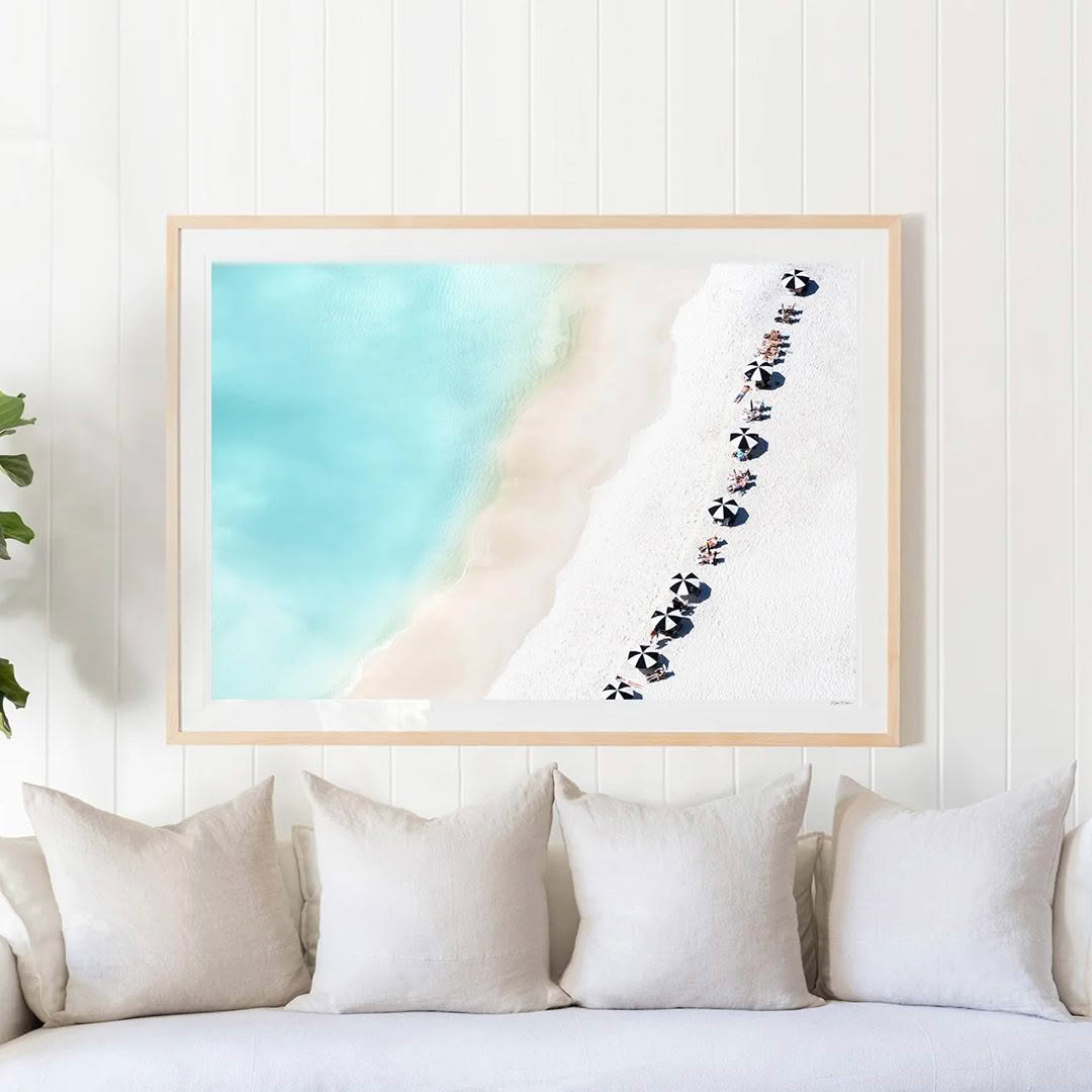 Beach aerial view art in frame above couch