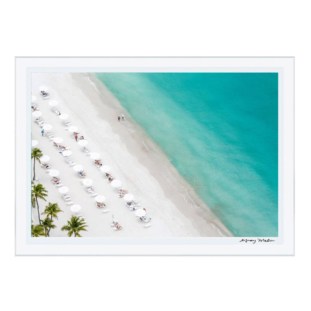 Aerial view of sandy beach with blue water and umbrellas