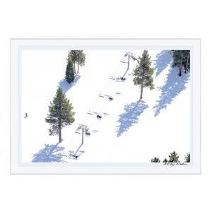 Skiers ascending snowy mountain on chairlift