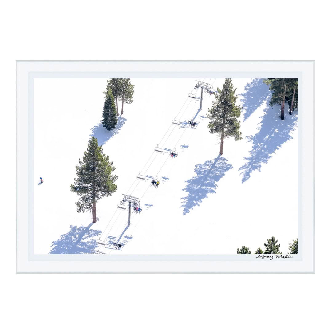 Skiers ascending snowy mountain on chairlift