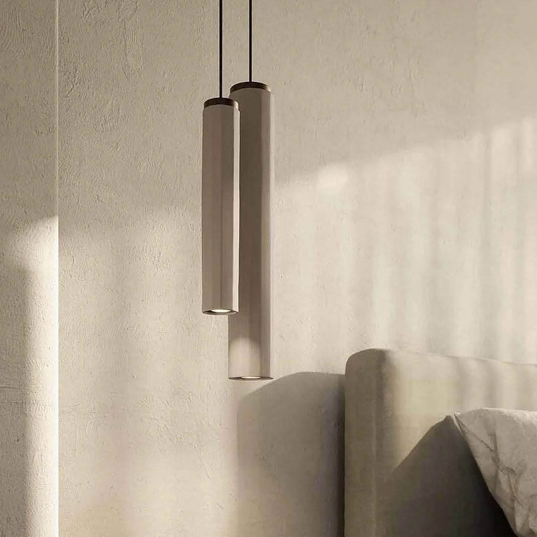 Minimalist pendant lights casting shadows on textured wall