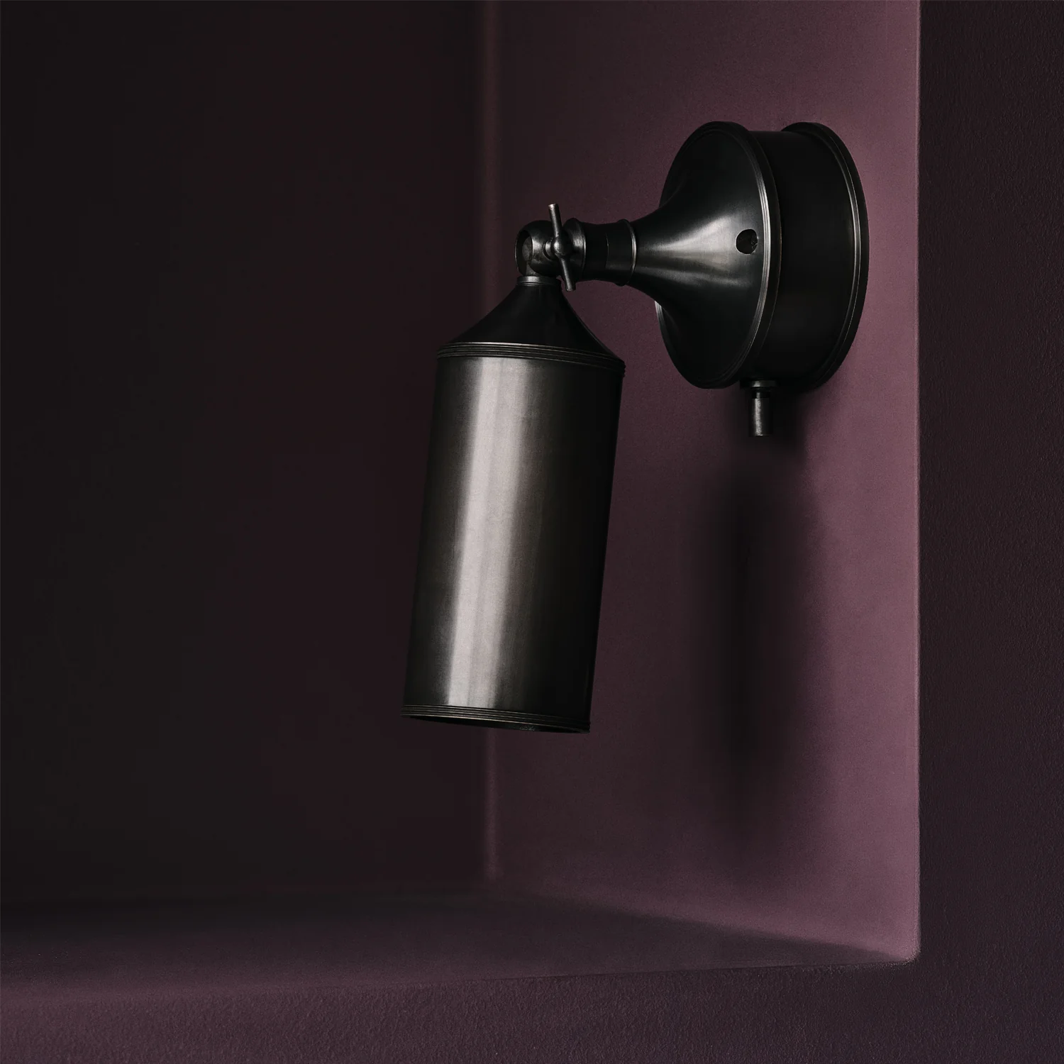 Black wall-mounted lamp on purple background