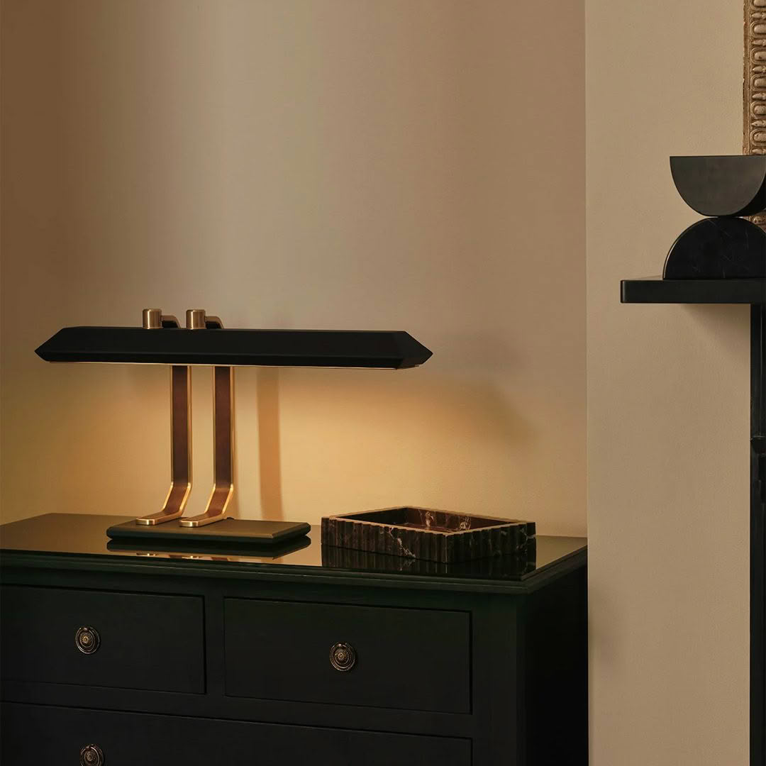 Elegant desk lamp on black drawer chest, warm lighting
