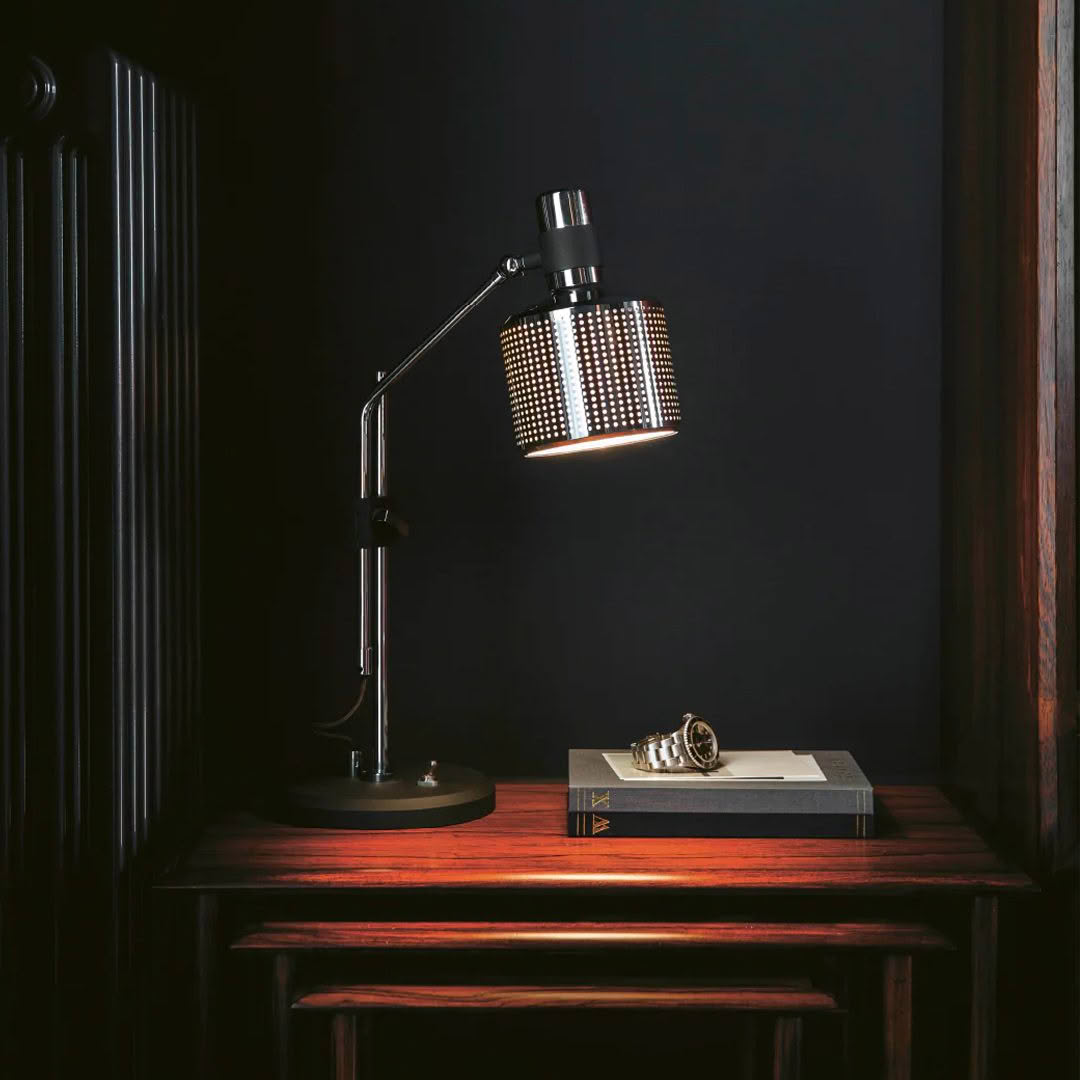 Vintage desk lamp illuminating book on wooden table