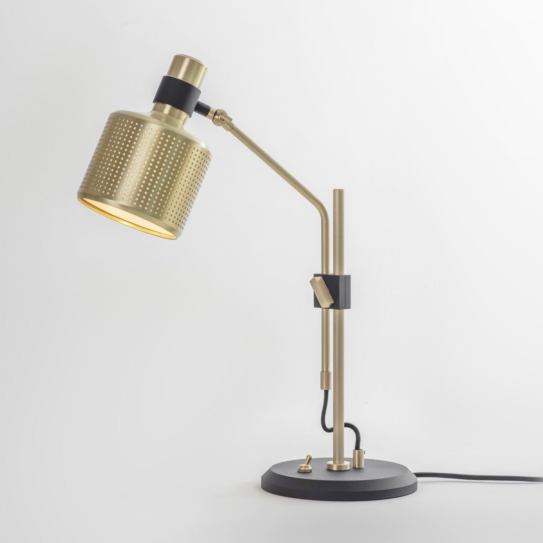 Gold desk lamp with adjustable arm on white background