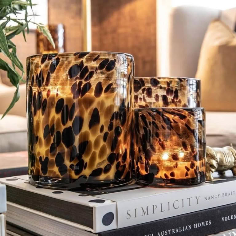 Tortoiseshell pattern glass candle holders on books