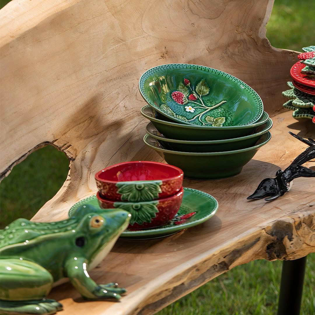Colorful ceramic bowls displayed on wooden table outdoors