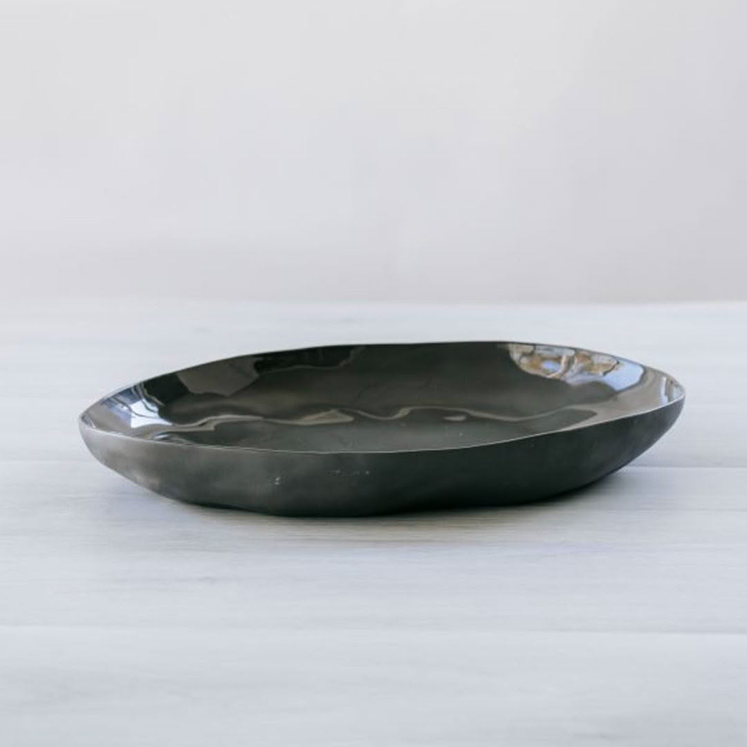 Dark ceramic decorative bowl on white surface