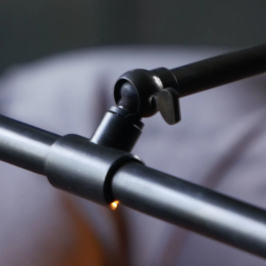 Close-up of a black metal clamp on a grey rod